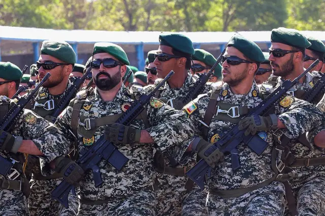 جنود يسيرون خلال عرض عسكري بمناسبة يوم الجيش الإيراني السنوي في طهران في 18 أبريل 2025، ويرتدون زياً عسكرياً حاملين السلاح وتغطي رؤوسهم قبعات بيضاء.