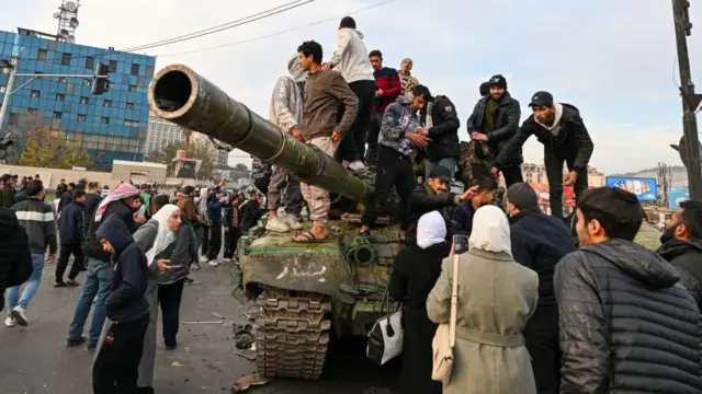 दमिश्क में टैंक पर सवार लोग