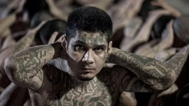 Un preso cubierto de tatuajes, con las manos tras la nuca en la gran cárcel de El Salvador. 