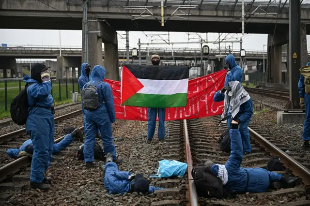 Activists block rails in Rotterdam port to protest NATO, Israeli military shipments
ROTTERDAM, NETHERLANDS - OCTOBER 11: Hundreds of pro-Palestinian activists from the 'Geef Tegengas' (Push Back) movement block a railway leading to the Port of Rotterdam protesting the port's involvement in NATO logistics and the transport of F-35 fighter jet components from Israel, in Rotterdam, Netherlands on October 11, 2025. Police officers intervene the demonstration and remove the protesters, who had chained themselves to the railway tracks. (Photo by Mouneb Taim/Anadolu via Getty Images)