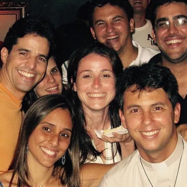 Guido sorri em meio a amigos