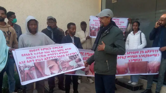 በውጭ ጉዳይ ሚኒስቴር መስሪያ ቤት የተሰባሰቡ ቤተሰቦች የተጎጂዎችን ፎቶ የሚያሳዩ ባነሮችን ይዘው