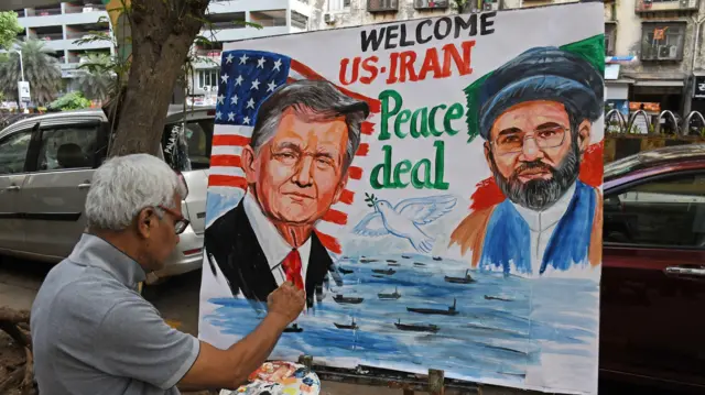 مومباي، ماهاراشترا، الهند - 16 يونيو/حزيران 2026 : معلم من مدرسة غوروكل للفنون يرسم ملصقًا يضم الرئيس الأمريكي دونالد ترامب والمرشد الأعلى الإيراني مجتبى خامنئي، يرحبان باتفاق السلام بين الولايات المتحدة وإيران خارج المدرسة