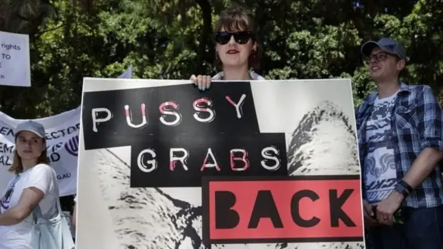 ผู้ประท้วงในออสเตรเลียชูแผ่นป้ายต่อต้านทรัมป์