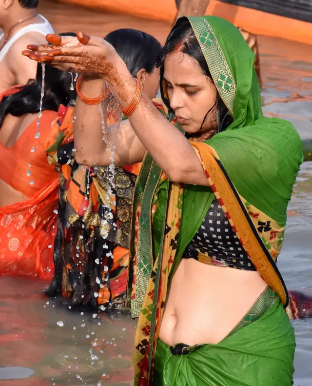 पटना में गंगा नदी के तट पर एक महिला छठ पूजा के दूसरे दिन