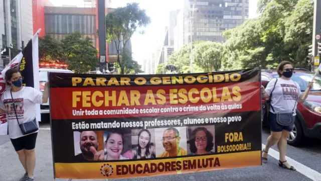 Duas mulheres seguram faixa na Avenida Paulista,cbet levelsSão Paulo, durante ato contra o retorno das aulas presenciais