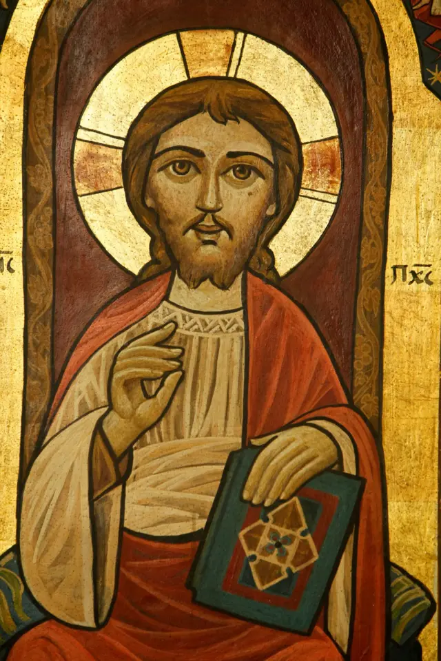 أيقونة قبطية تمثل السيد المسيح جالساً ويمسك في يده الكتاب المقدس