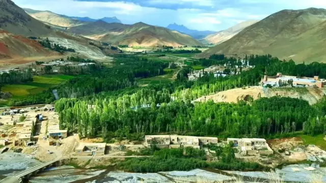 درختان سرسبز، خانههای روستایی در میانه سه کوه در یکی از مناطق بامیان