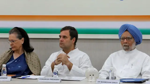 Rahul Gandhi, President of Congress party(c) wearing a white traditional indian shirt sits with his hands folded, his mother and leader of the party Sonia Gandhi is wearing a navy blue saree with an olive green scarf a and India's former Prime Minister Manmohan Singh wearing a white traditional indian shirt and hus trademark blue turban attend a Congress Working Committee (CWC) meeting in New Delhi, India, May 25, 2019.