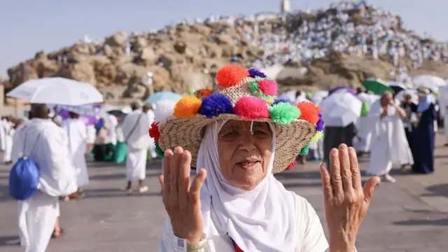 سيدة ترتدي غطاء رأس مزيناً بالألوان على جبل عرفات