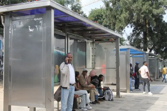 አዲስ አበባ አውቶብስ መጠበቂያ ላይ የተቀመጡ እና የቆሙ ሰዎች