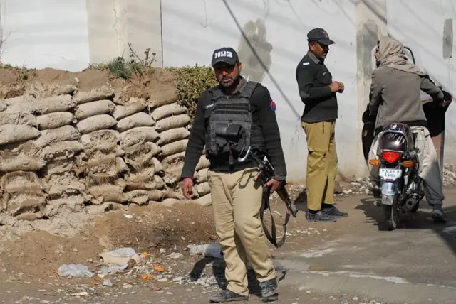 پاکستاني پولیس برېښي چې پر موټرسایکل یو سپور کس یې درولی دی او ورسره غږېږي.