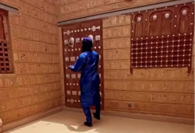 Un homme ouvrant la porte d'un édifice en banco à Tombouctou.