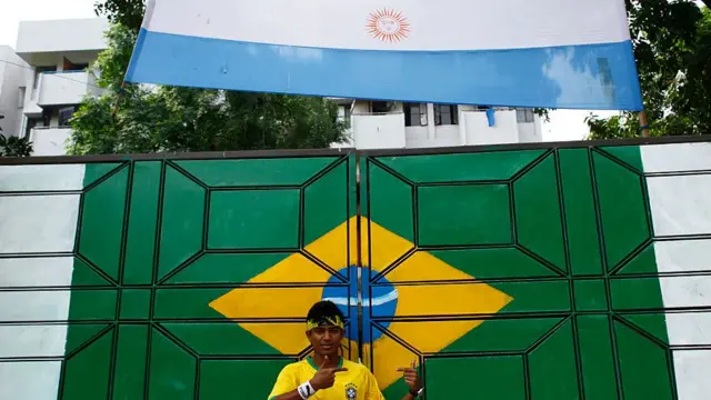 Torcedor tira selfielima sportfrente à bandeira do Brasil