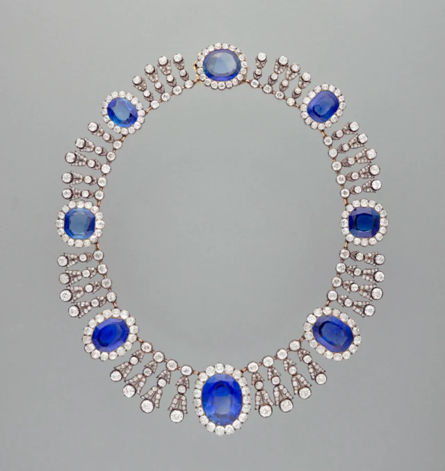Un collar de plata decorado con gemas azules y diamantes.