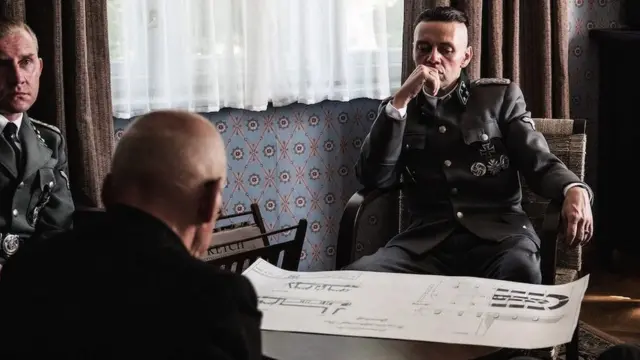 Rudolf Hes je prikazan na sastanku, ali jezive posledice njegovog komandovanja se samo mogu čuti