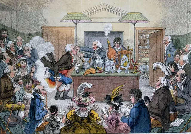 Demostración en la Royal Institution del gas de la risa que conduce a la pérdida de inhibiciones en la primera etapa de la anestesia. La caricatura se titula: "Investigaciones científicas. Nuevos descubrimientos en neumática, o una conferencia experimental sobre los poderes del aire".