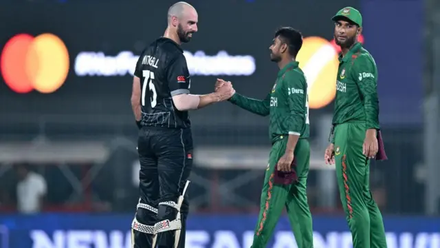 ম্যাচের শেষে ড্যারিল মিচেল হাত মেলাচ্ছেন মেহেদি হাসান মিরাজের সঙ্গে