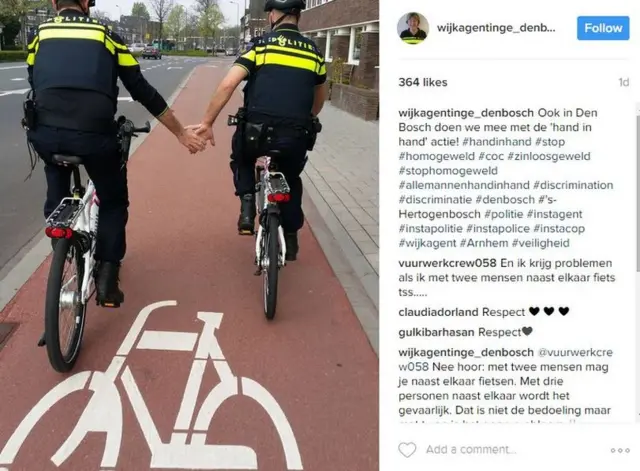 Un post de Instagram que muestra a dos policías montados en bicicletas tomándose de la mano.