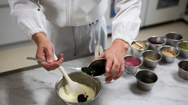 ટેબલ પર અલગ અલગ સામગ્રીમાંથી એક પદાર્થ બનાવતો વ્યક્તિ