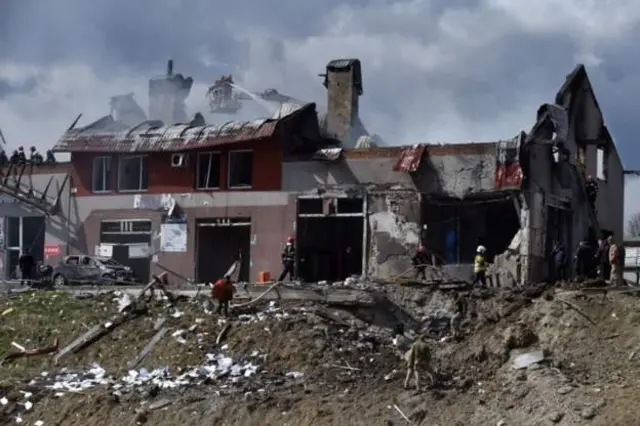 เจ้าหน้าที่ดับเพลิงพยายามควบคุมเพลิงที่บริเวณอาคารที่ถูกขีปนาวุธโจมตีในเมืองลวิฟทางตะวันตกของยูเครน