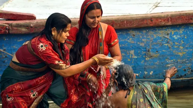 वाराणसी में खरना पूजा के दिन अस्सी घाट पर स्नान करतीं महिलाएं