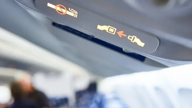 Señal de abrocharse el cinturón en el avión.