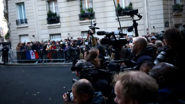 Журналисты с камерами и сторонники Саркози (за ограждением) на парижской улице.