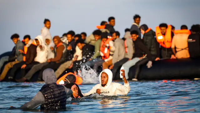 Migrantes abordan una lancha inflable durante un intento de cruzar el Canal de la Mancha, frente a la playa de Gravelines, en el norte de Francia, el 27 de septiembre de 2025.