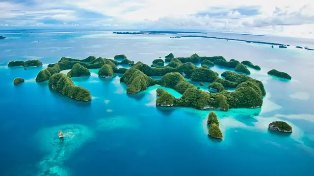 Fotografia colorida mostra ilhotas verdescoritiba e santosum mar muito azul