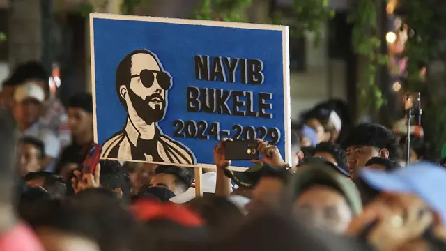 Um desenho em uma placa representando o presidente Nayib Bukele, em meio a uma multidão de apoiadores