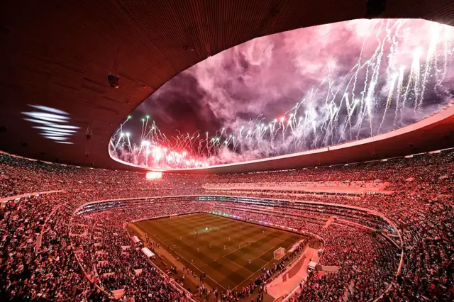 Fuegos artificiales explotan sobre un Estadio Azteca lleno en su reinauguración.