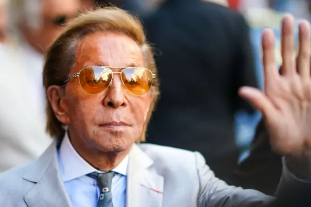 Garavani el sallayarak bir davete katılanları selamlıyor.