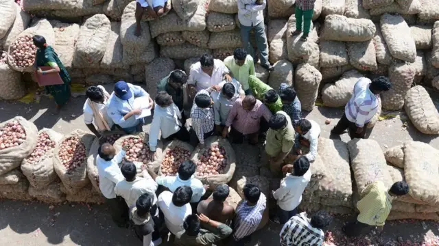 ખેતીવાડી ઉત્ત્પન બજાર સમિતિના પટાંગણમાં ખેડૂતો અને વેપારીઓ દ્વારા ખેતપેદાશોના (ડુંગળી ભરેલા કોથળાઓના) થઇ રહેલા સૌદાની પ્રતીકાત્મક તસ્વીર