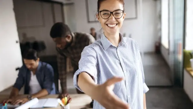 Девушка тянет руку в рукопожатии при заключении сделки