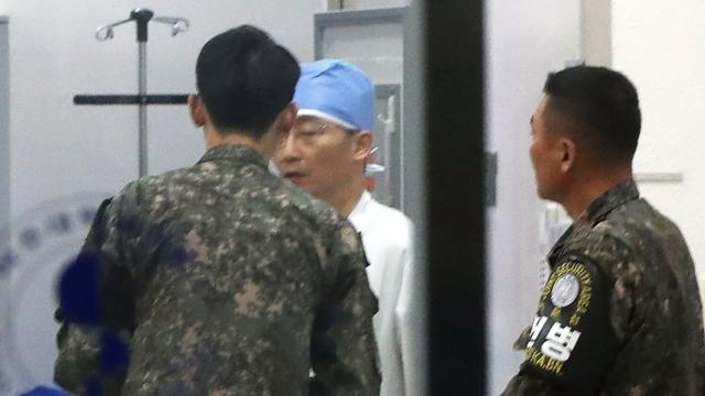 Los medios retrataron el lunes a un médico conversando con funcionarios del ejército surcoreano que llevaban identificación de la Zona de Seguridad Conjunta en un hospital de Suwon, en el sur de Seúl.