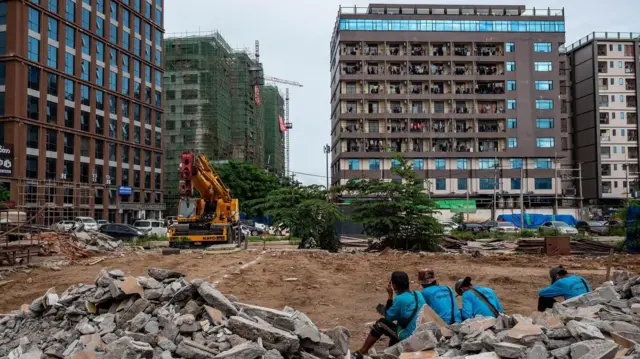 Trabajadores con camiseta azul en un solar donde se construirá un edificio en Shwe Kokko.