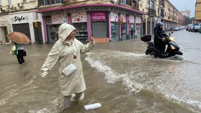 Varias personas en una calle inundada en Málaga