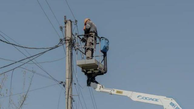 عامل في بلدية خاركيف يعمل على صيانة خطوط الكهرباء التي تضررت بقصف روسي قبل أيام