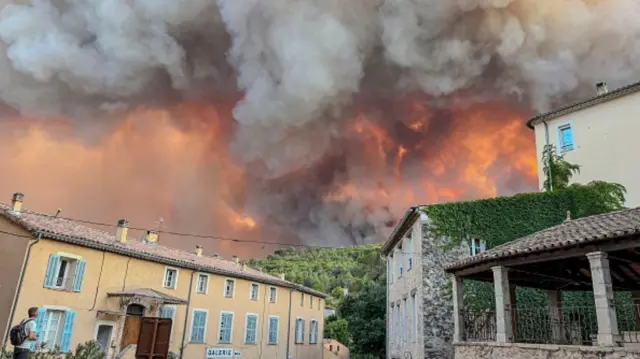 Smoke and flames dey visible from one wildfire on July 21, 2026 in Cotignac, France.