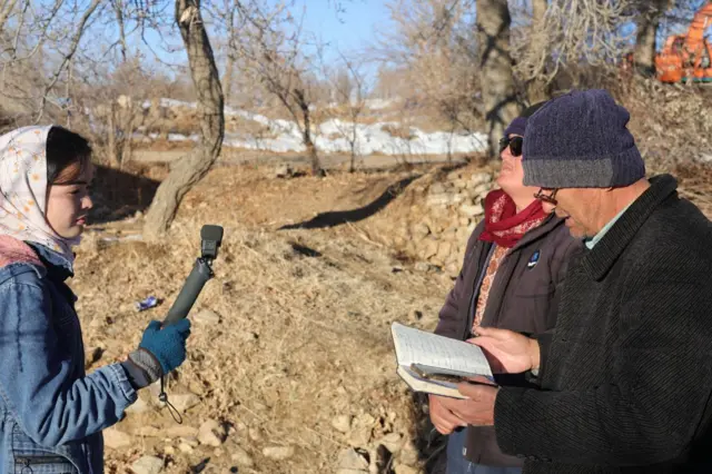 انجنیر خالق نجیر در حال خواندن کتابچه و شمامه در حال ثبت صدا 