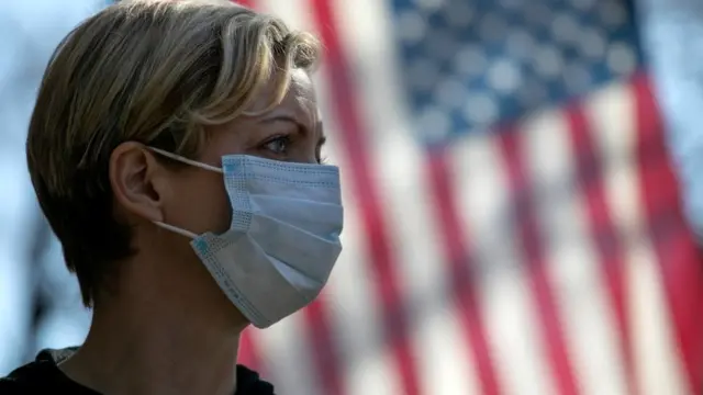 Coronavirus crisis volunteer Rhiannon Navin greets local residents arriving to a food distribution centre in New York