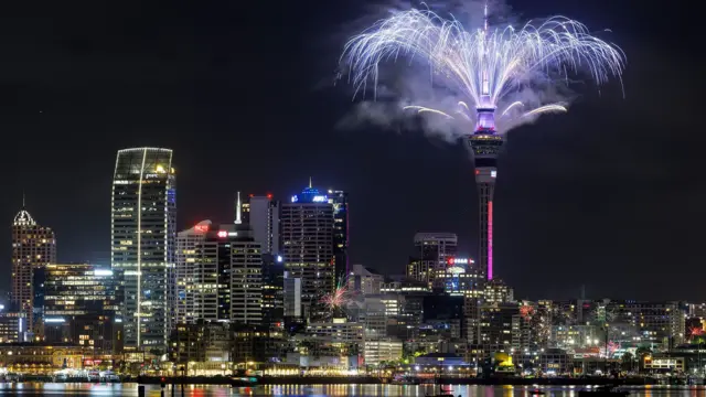 A city skyline with a firework display from the top of Auckland's Sky Tower
