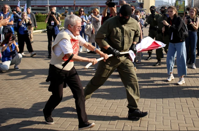 Багинская на одной из акций протеста в Минске: силовик вырывает у нее из рук красно-белый флаг