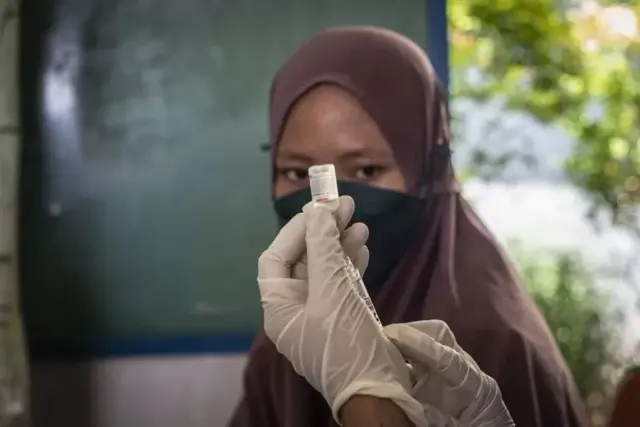 Seorang perempuan menerima vaksin virus Covid-19.