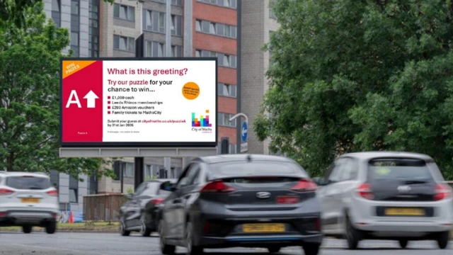 Un rompecabezas en una valla publicitaria en una carretera transitada de Leeds. Los coches se ven borrosos en primer plano.