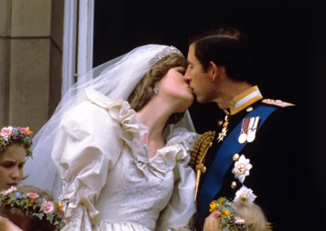 Os recém-casados príncipe e princesa de Gales se beijam na varanda do palácio de Buckingham após a cerimônia na catedral de St. Paul