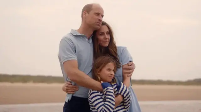 A imagem mostra o princípie William abraçado com Kate e com a filha, a prinecsa Charlote. 