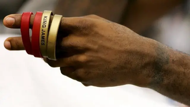 LeBron James plays with his 'King James' wrist bands as he sits on the bench against the Portland Trail Blazers on 17 January, 2006