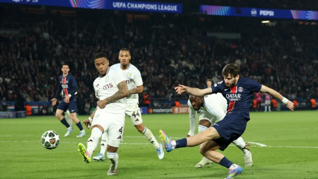 Players aiming for the ball on the pitch